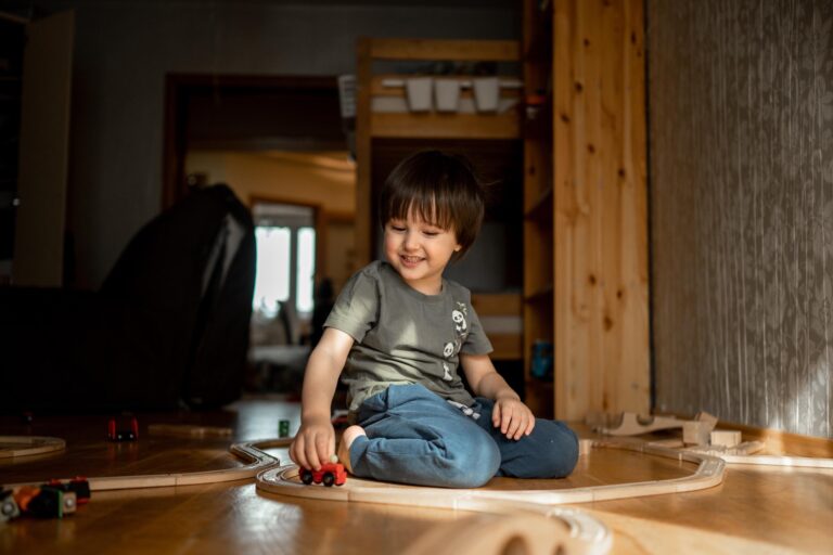 Der Junge spielt zu Hause Kindereisenbahn.